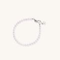 Delicate sterling silver bracelet with small freshwater pearls and adjustable chain on neutral background.