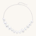 Sterling silver necklace with asymmetrically placed white pearls of varying sizes on neutral background