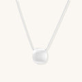 Minimalist sterling silver necklace with brushed square pendant on adjustable chain against white background.