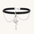 Black leather choker with gold-plated serpent pendant and crystal droplet on white background, adjustable chain design