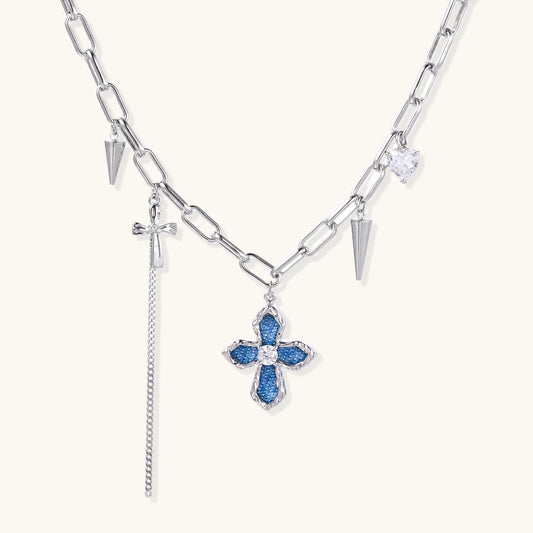 18K gold plated brass chain necklace featuring blue cross pendant with zirconia center stone and spike charms on white background.
