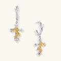 Ornate cross-shaped dangle earrings with gold roses and sparkling zirconia stars on silver-toned base with hoop closures.