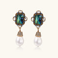 Gold-plated brass drop earrings featuring iridescent abalone shell centers, crystal accents, and white pearl drops.