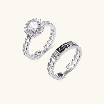 Two gold-plated rings with chain-link bands, one featuring cubic zirconia halo setting, displayed on neutral background